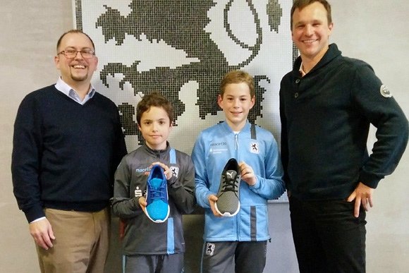 Die U11-Spieler Julius Beukelmann (2.v.l) und Max Schmitt (3.v.l) nehmen stellvertretend für die Junglöwen die Schuhe von Erik Altmann (1.v.l.) und Juniorenleiter Roy Matthes (4.v.l) entgegen. 