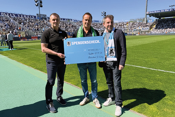 Der 1. Vorsitzenden der Unternehmer für Sechzig e.V., Peter Lechner (Mitte), übergibt den Scheck an Manfred Paula (li) und Präsident Gernot Mang (re.). Foto: Uf60